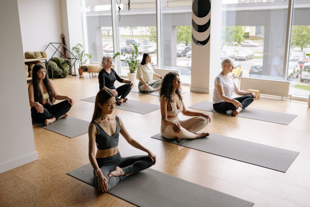 group-of-women-doing-yoga-exercise-8436719 Women of various ages practice yoga meditation indoors in a serene studio.